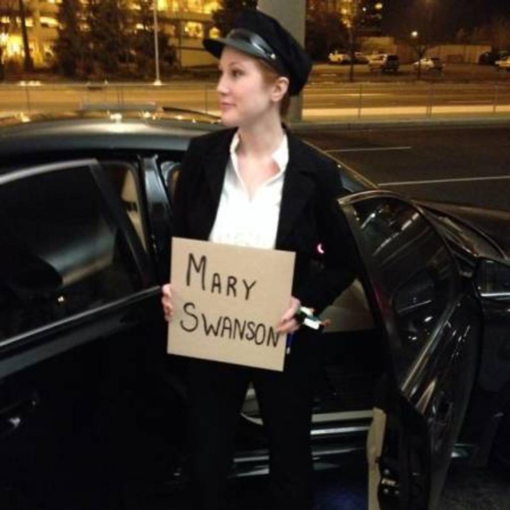 A woman holding a funny airport greeting sign.