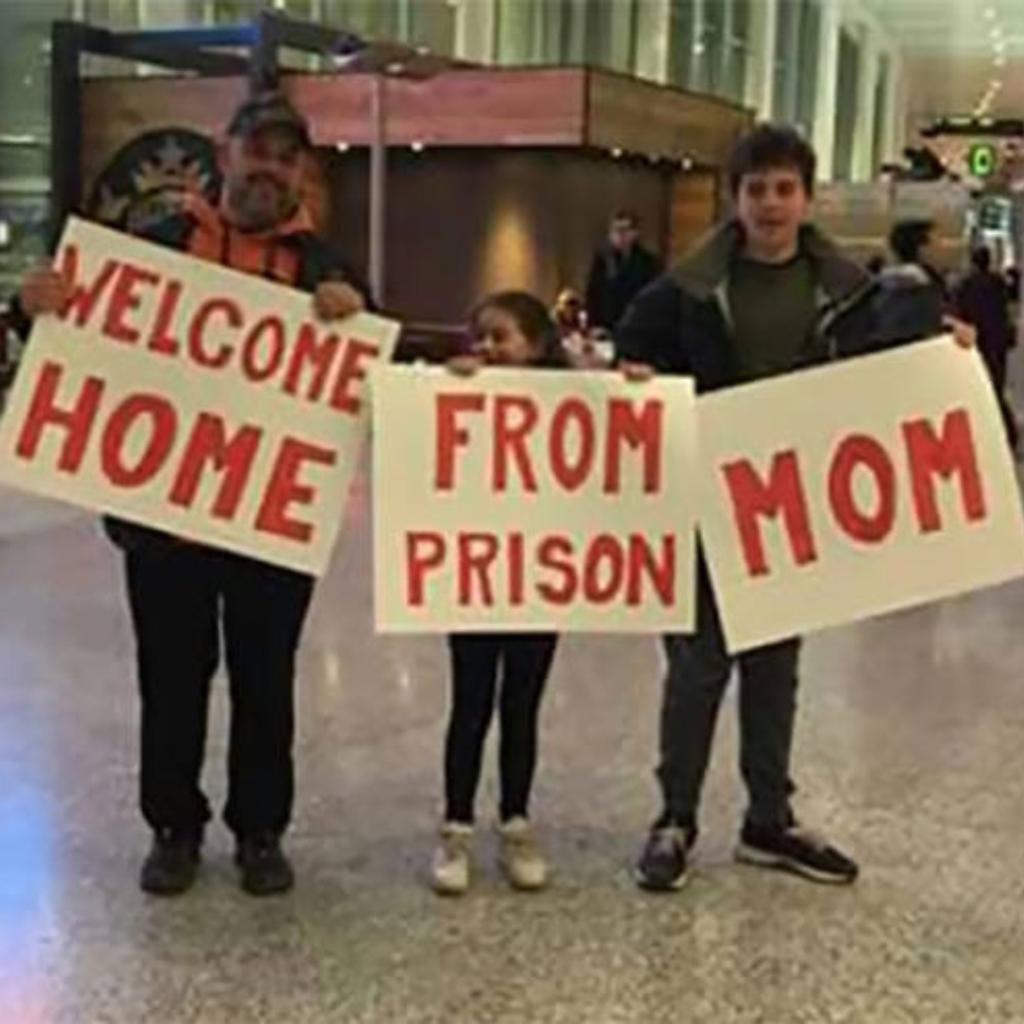 A family holding funny airport greeting signs.